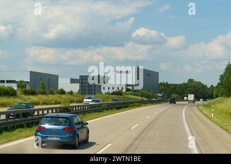 Fahrzeuge, die auf einer Autobahn unter klarem Himmel fahren, mit einem großen Betzold-Schild auf einem angrenzenden Gebäude. Stockfoto