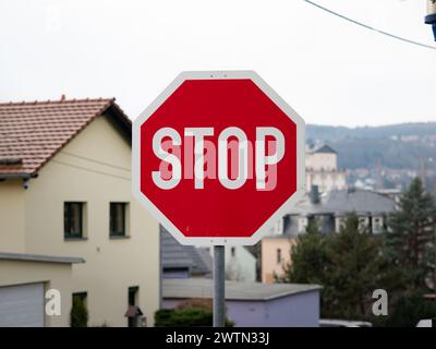 Halten Sie das Straßenschild in Deutschland an. Vorrang für andere Autofahrer an der Kreuzung einer Seitenstraße. Warnschilder als Verkehrsvorschrift. Stockfoto