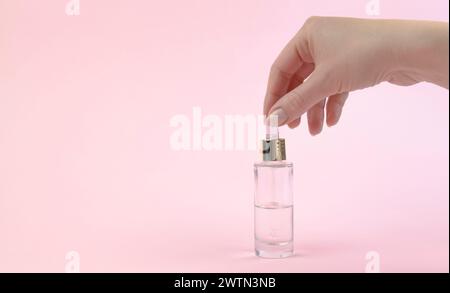 Die Hand einer Frau hält eine Pipette mit Serum. Ätherisches Öl. Das Konzept der natürlichen Hautpflege. Stockfoto