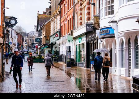 Die lebhafte High Street im Stadtzentrum, ein regnerischer Tag. Winchester, Hampshire, England, Vereinigtes Königreich, Europa Stockfoto