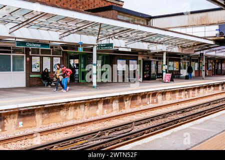 Passagiere, die auf dem Bahnsteig warten. Bahnhof Chichester. Chichester, West Sussex, South East, England, Vereinigtes Königreich, Europa Stockfoto