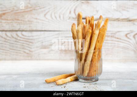 Grissini mit Kräutern auf grauem Betonhintergrund. Stockfoto