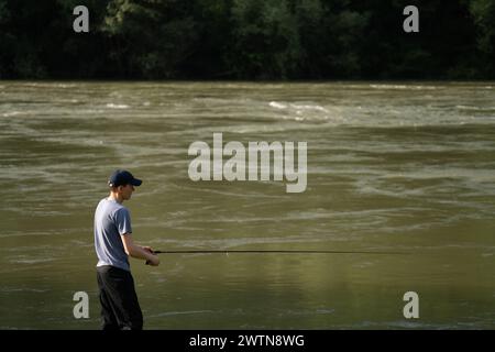 Mann fischt am Abend auf dem Bergfluss. Stockfoto
