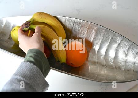Obstvariante in einer stilvollen Schüssel auf einer weißen Küchenzeile. Stockfoto