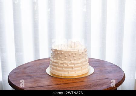 Weißer Partykuchen mit weißer Glasur und Perlen, Kuchendesign. Handgemachter Kuchen für einen besonderen feierlichen Anlass. Kopierbereich Stockfoto