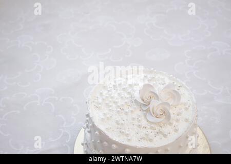 Weißer Partykuchen mit weißer Glasur und Perlen, Kuchendesign. Handgemachter Kuchen für einen besonderen feierlichen Anlass. Kopierbereich Stockfoto