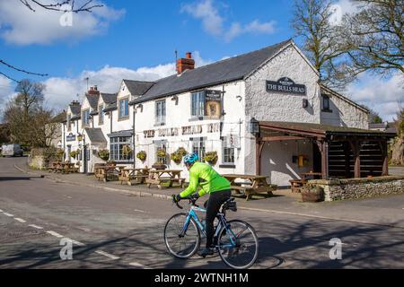 Radfahrer fahren am The Bulls Head vorbei, einem traditionellen englischen kutschenhaus im Derbyshire Peak District Dorf Foolow England, Großbritannien Stockfoto