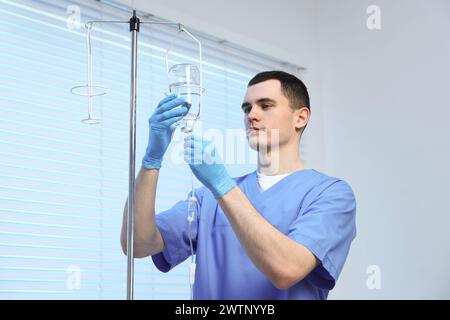 Krankenschwester, die IV-Tropf im Krankenhaus einrichtet Stockfoto