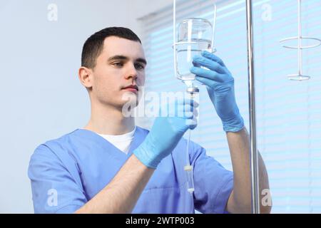 Krankenschwester, die IV-Tropf im Krankenhaus einrichtet Stockfoto