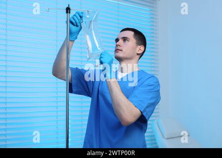 Krankenschwester, die IV-Tropf im Krankenhaus einrichtet Stockfoto