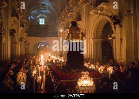 Malaga, Spanien. März 2024. Die Statue Christi wird von den Bußleuten der Bruderschaft „Humildad“ getragen, während sie am Kreuzgang teilnehmen, der die Statue Christi in ihren Wagen in der Kirche Santuario de la Victoria vor Beginn der Karwoche am Palmensonntag überführt. In den letzten Wochen tragen Dutzende Brüderschaften ihre Ikonen in ihre Kirchen, die traditionellen Rituale, umgeben von Kerzenlicht, befolgen. (Foto von Jesus Merida/SOPA Images/SIPA USA) Credit: SIPA USA/Alamy Live News Stockfoto