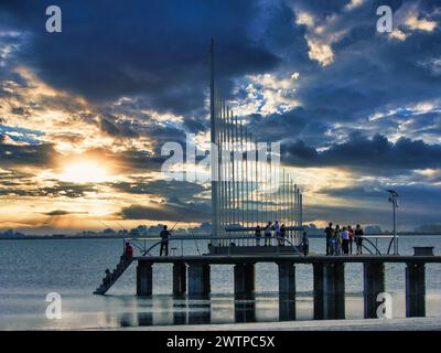 Sonnenuntergang am Pier mit Fischern in der Lagune von Gomez Stockfoto