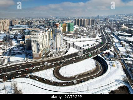 Panoramablick auf die Alfarabi Avenue mit Autoverkehr und großen Gebäuden im Winter in Almaty City, Kasachstan Stockfoto