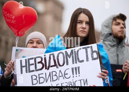 Traurige ukrainische Frau hält das Banner „die unbekannten Tötungen“ auf einer Demonstration, die den vermissten und gefangenen Ukrainern gewidmet ist, die in russischen Gefängnissen verbleiben. Kiew - 16. März 2024 Stockfoto