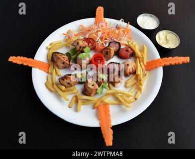 Chicken Shish Tawook sind Hühnchenkebabs, gebadet in einer kräftigen Joghurtmarinade mit Zitrusfrüchten, Knoblauch und vielen warmen Gewürzen, serviert mit Pommes frites. Stockfoto