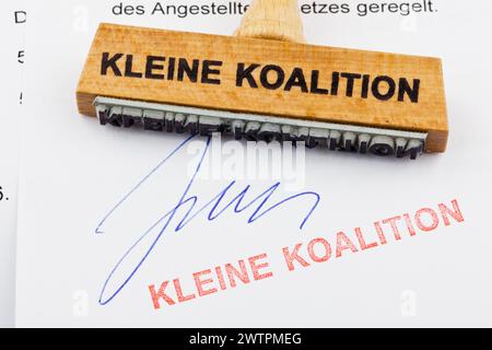 Ein Holzstempel liegt auf einem Dokument. Deutsche Inschrift: Kleine Koalition Stockfoto