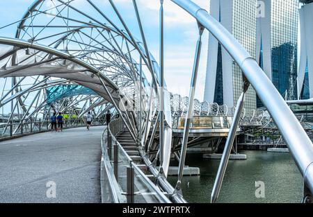 Singapur, 24. Januar 2024: Helix Bridge mit Blick auf Marina Bay Sands, moderne Architektur und berühmte Skyline. Die Brücke überspannt die Bucht, Highlight Stockfoto