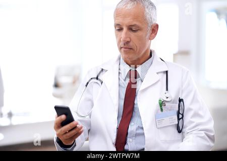Gesundheitswesen, Mann und Arzt mit Smartphone im Krankenhaus für Wellness-Forschung, medizinische App oder Online-Beratung. Klinik, Beratung und reifer Arzt per Handy Stockfoto