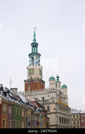 Ein Foto des alten Marktplatzes in Poznań, Polen, aufgenommen im Januar während des Winters. Schneebedeckte Dächer mit dem historischen Rathaus vor einem weißen Stockfoto