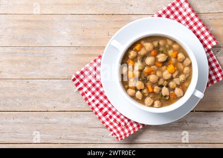Kichererbsensuppe mit Gemüse in einer Schüssel auf Holztisch Stockfoto