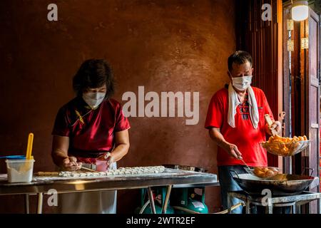 Jomtien, Thailand, 10. Februar 2024: Chakngeaw Chinese Village. Ein Paar macht Youtiao, einen langen goldbraunen, frittierten Streifen Weizenmehlteig. Stockfoto