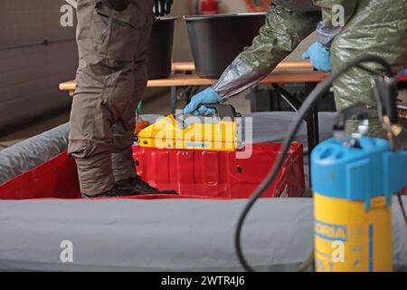 Beamte des Spezialeinsatzkommandos der bayerischen Polizei SEK in Schutzkleidung werden in einer von der Feuerwehr eingerichteten Station zur Dekontaminierung von der Feuerwehr mit Messgeräten überprüft und nach Sicherung und Ablegung der persönlichen Schutzausrüstung dekontaminiert. Länderübergreifende Großübung der Spezialeinheiten Terrorismusbekämpfung CTE 2024. Sulzbach-Rosenberg Bayern Deutschland *** Offiziere der Sondereinsatzgruppe der bayerischen Polizei SEK in Schutzkleidung werden von der Feuerwehr mit Messgeräten in einer durch das Feuer eingerichteten Dekontaminationsstation überprüft Stockfoto