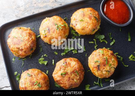 Perkedel indonesische gebratene Kartoffelhackenfleisch mit Soßen-Closeup auf dem Teller auf dem Tisch. Horizontale Draufsicht von oben Stockfoto
