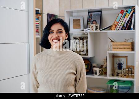 Ein Porträt der Schönheit: Eine schwarzhaarige Frau badet im warmen Licht ihres Wohnzimmers Stockfoto