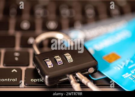 Ein Sicherheitskonzept für Online-Zahlungen mit einer Kombination aus Vorhängeschloss und Kredit-, Debitkarten auf der Tastatur eines Laptops. Stockfoto