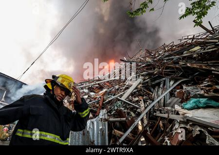 Quezon City, Philippinen. März 2024. Feuerwehrleute arbeiten in der Nähe des Ortes eines Feuerunfalls in Quezon City, Philippinen, 19. März 2024. Nach Angaben der örtlichen Behörden waren etwa 400 Familien von einem Feuerunfall betroffen, der sich am Dienstag in Quezon City ereignete. Quelle: Rouelle Umali/Xinhua/Alamy Live News Stockfoto