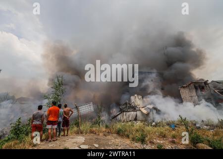 Quezon City, Philippinen. März 2024. Die Einwohner stehen in der Nähe verbrannter Gebäude in Quezon City, den Philippinen, 19. März 2024. Nach Angaben der örtlichen Behörden waren etwa 400 Familien von einem Feuerunfall betroffen, der sich am Dienstag in Quezon City ereignete. Quelle: Rouelle Umali/Xinhua/Alamy Live News Stockfoto