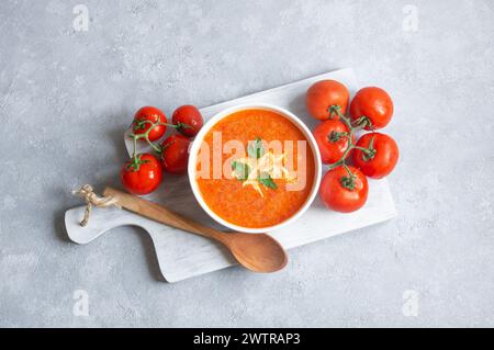 Tomatensuppe in einer Schüssel mit frischen Bio-Tomaten auf dem Tisch, gesunde hausgemachte traditionelle Suppe Stockfoto