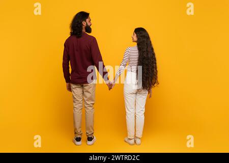 Rückansicht eines Paares, das die Hände zusammenhält Stockfoto