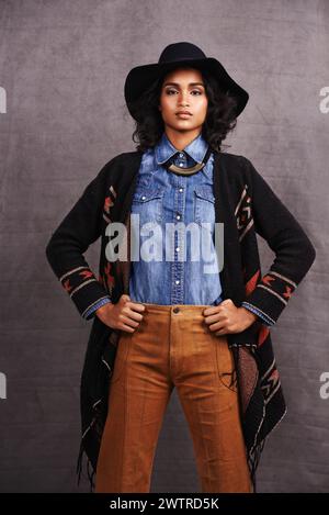 Mode, Cowgirl oder Frau Vertrauen in Porträt, Studio und coole Kultur oder Kleidung auf grauem Hintergrund. Amerikanischer Ureinwohner, westlich und stilvoll Stockfoto