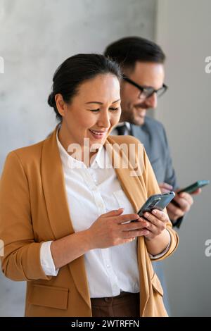 asiatische Geschäftsfrau mittleren Alters, die im Büro telefoniert Stockfoto