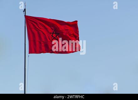 Die Flagge Marokkos flattert auf blauem Himmel Hintergrund Stockfoto