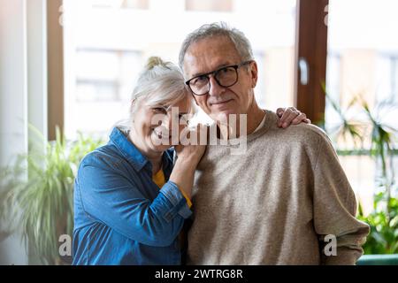 Porträt von senior Brautpaar umarmen einander im Wohnzimmer zu Hause Stockfoto