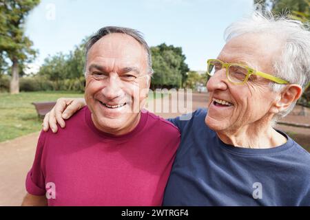 Zwei männliche Seniorenfreunde, die Spaß beim Training haben Laufen im Stadtpark - glückliche, reife Männer, die Fitness im Freien machen - Sport und elendig gesund l Stockfoto