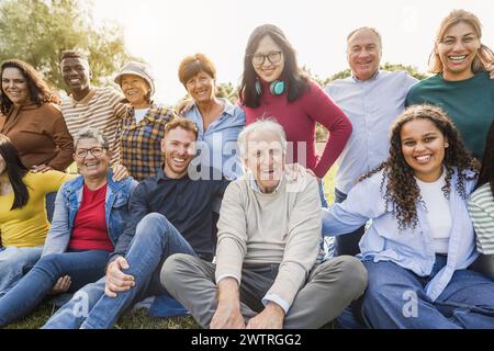 Gruppe von Menschen, die mehrere Generationen haben und vor der Kamera lächeln - multiethnische Freunde unterschiedlichen Alters, die gemeinsam Spaß haben - Schwerpunkt auf asiatischem Zentrum Stockfoto