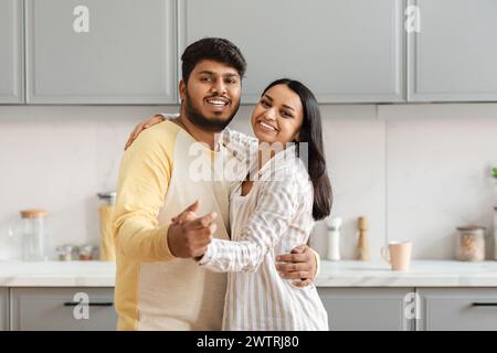 Liebendes junges indisches Paar, das in der Küche tanzt Stockfoto