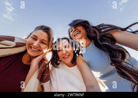 Eine Gruppe junger, attraktiver multiethnischer Frauen macht Selfies und lacht draußen. Lächelnde Freundinnen verschiedener Rassen haben Spaß und machen Fotos Stockfoto