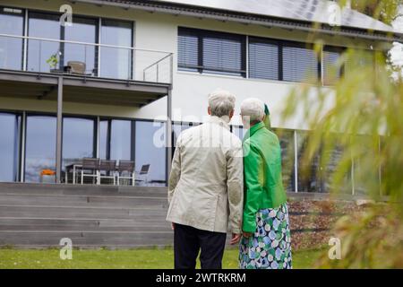 Rückansicht eines älteren Ehepaares vor ihrem Haus Stockfoto