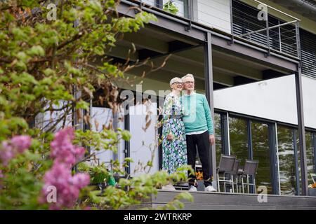 Senior Pärchen stehen vor ihrem Haus Stockfoto