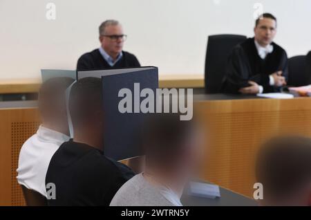 Augsburg, Deutschland. März 2024. Der Hauptangeklagte (l) sitzt neben anderen Angeklagten im Dock eines Gerichtssaals. Er wird angeklagt, dass er einen Sprengstoff explodieren lässt und schwere körperliche Schäden verursacht. Am 11. November 2023 soll der Mann während des in Deutschland nicht zugelassenen Bundesliga-Spiels zwischen dem FC Augsburg und der TSG 1899 Hoffenheim einen Feuerwerkskörper im Besucherblock ausgelöst haben. Vermerk: Karl-Josef Hildenbrand/dpa - ACHTUNG: Person(en) wurde/wurden aus rechtlichen Gründen pixeliert/dpa/Alamy Live News Stockfoto