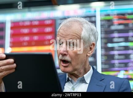 Senior Trader sieht schockiert auf seinen Laptop aus. Stockfoto