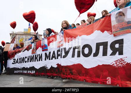 Ukrainische Frauen halten ein Banner "Verteidiger von Mariupol" und Porträts von gefangenen Soldaten, die seit 2022 in russischen Gefängnissen verbleiben. Kiew - 16. März 2024 Stockfoto