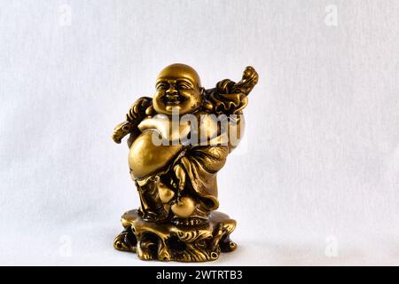 Bronzestatue von Buddha, der mit einer Tasche auf der Schulter geht, Vorderansicht, Souvenir Stockfoto