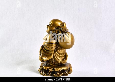 Bronzestatue von Buddha, der mit einer Tasche auf der Schulter geht, Seitenansicht, Souvenir Stockfoto