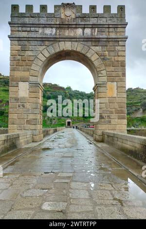 Triumphbogen der Trajanbrücke in Alcantara, römische Steinbogenbrücke, kleiner römischer Tempel auf der linken Uferseite im Hintergrund, Caceres, Spanien Stockfoto