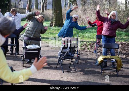 PRODUKTION - 13. März 2024, Sachsen-Anhalt, Köthen: Senioren nehmen an einem Rollator-Yoga-Kurs für Senioren im Schlosspark Köthen Teil. Der Kurs bietet gezielte Übungen, die auf und außerhalb des Rollators durchgeführt werden können. Foto: Jan Woitas/dpa Stockfoto